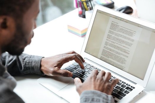 Beschnittenes Foto des ernsten jungen Mannes, der im B&uuml;ro Coworking sitzt