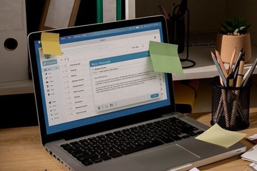 Sicht auf einen B&uuml;ro-Schreibtisch mit unordentlichem Arbeitsbereich und Laptop