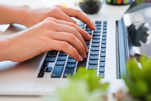 Nahaufnahme der H&auml;nde, die auf der Tastatur tippen